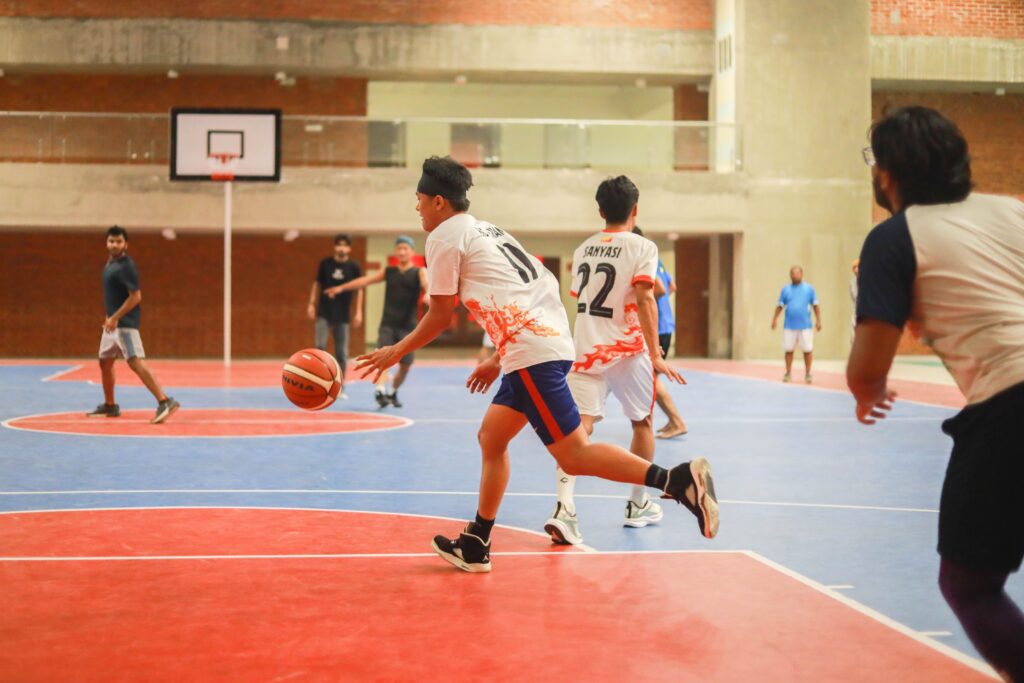 Energetic basketball game in an indoor court with players in motion, showcasing teamwork and agility.